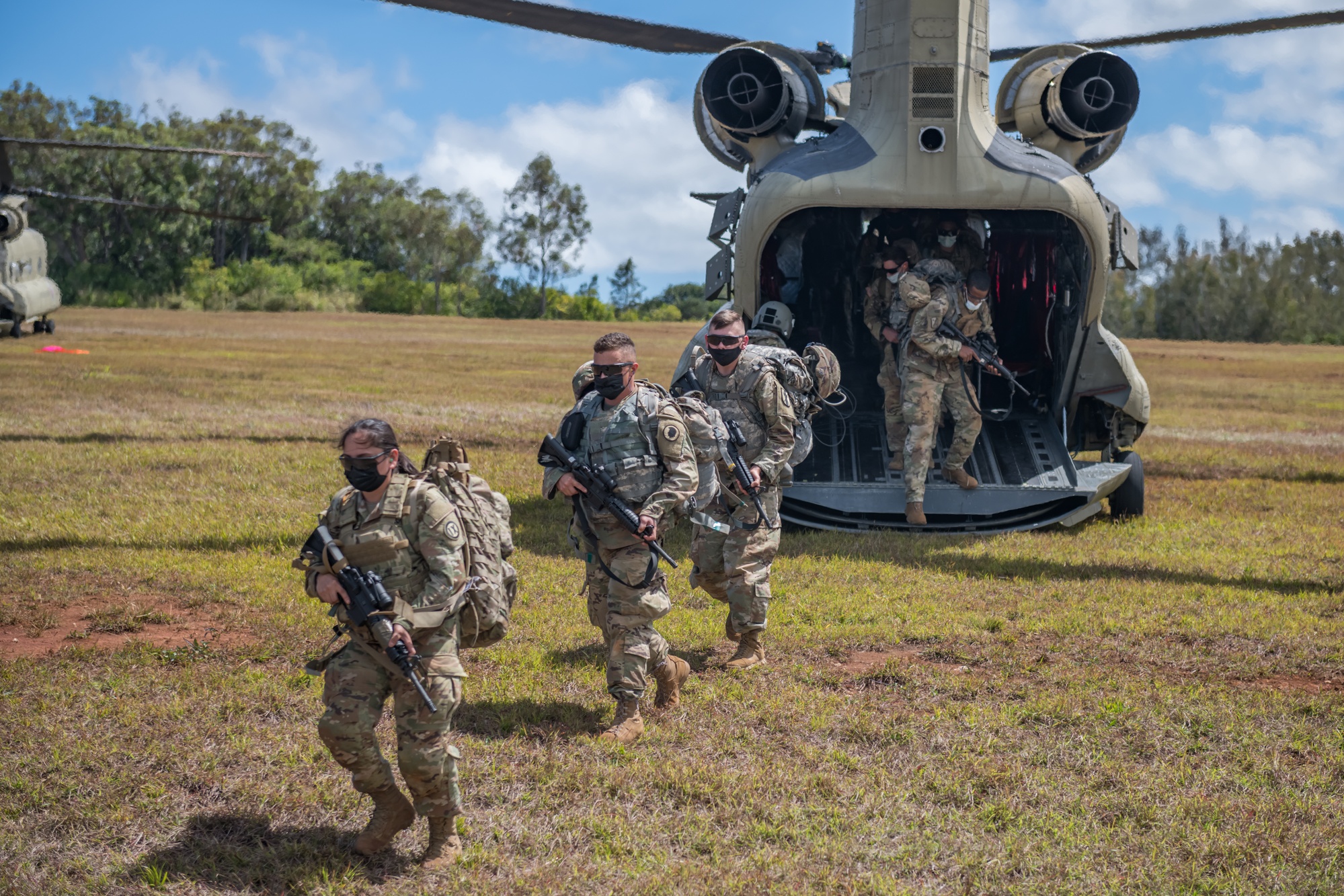 Soldiers leaving a helicopter during Hawaiʻi Guard training